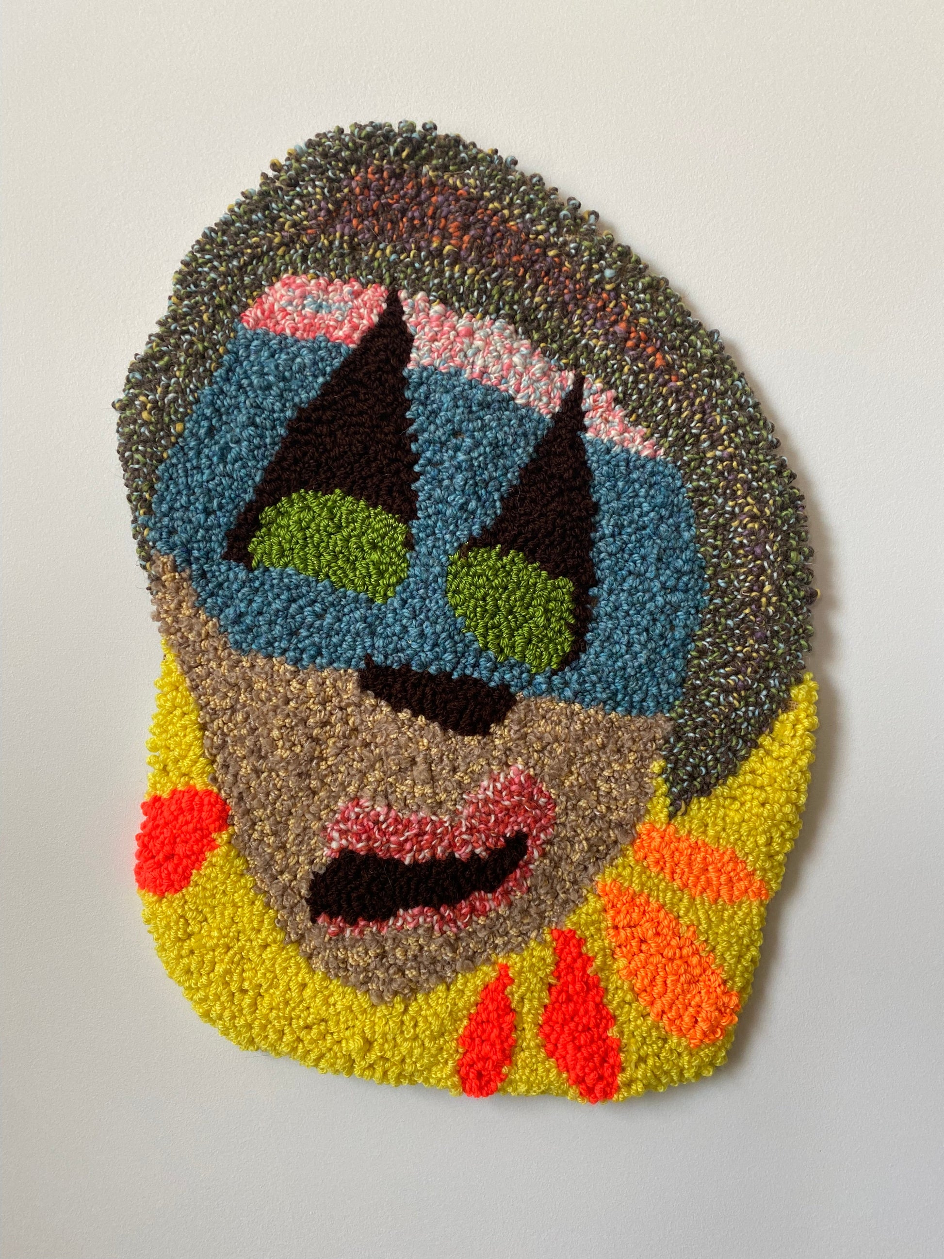 Colorful abstract face art piece on a plain background