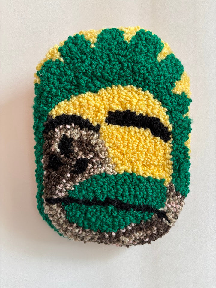 Yarn face with green, yellow, and gray colors on a white background